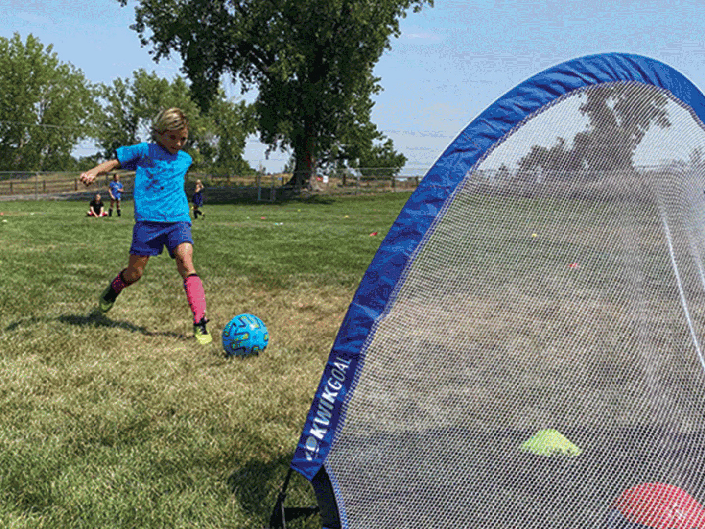 Boy shooting ball into soccer net