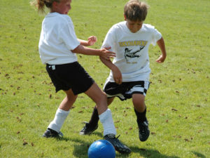Girl and Boy Playing at Soccer Camp