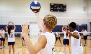 Boy serving volleyball